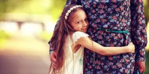 A little girl hugging her mother, making it difficult for her while writing a parenting plan in NJ