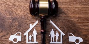 A gavel dividing a family home and car to depict child custody and dividing of financial assets as key reasons why you need a divorce lawyer